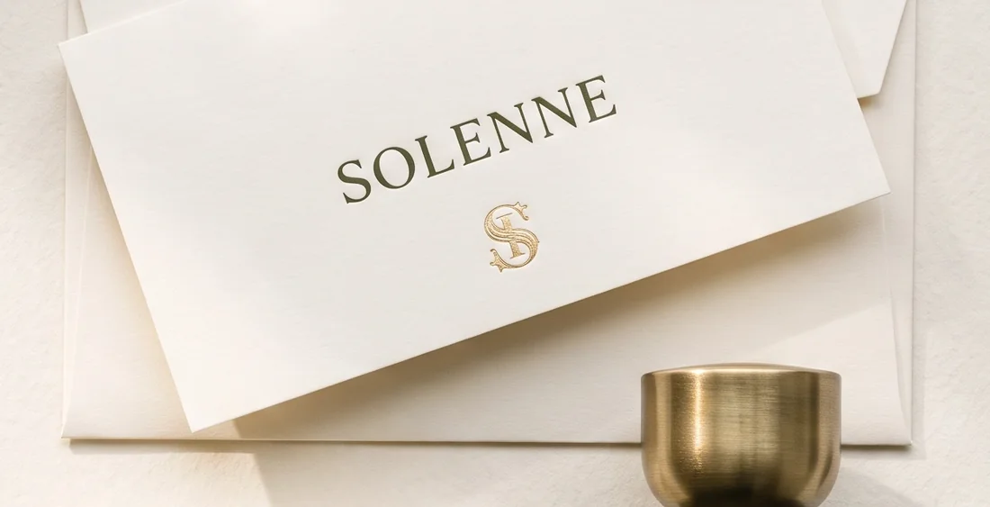 Letterhead and envelope, wordmark in deep olive with a gold-foil S monogram beneath.